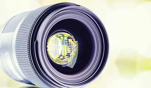 機器のビデオカメラマンと写真家 明るいランプの背景にテーブルの上のレンズ カメラのガラスの反射によるグレアとボケ — ストック写真