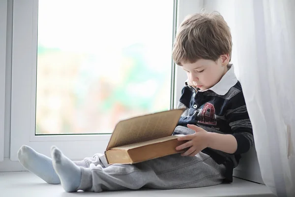 Den Lilla Pojken Läser Bok Barnet Sitter Vid Fönstret Och — Stockfoto