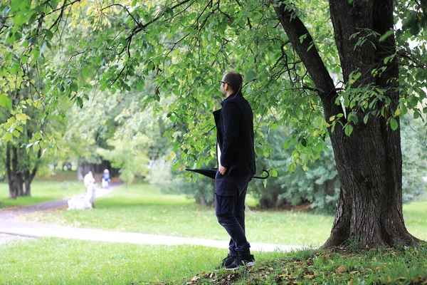 Молодий Чоловік Окулярах Гуляє Парку Парасолькою Під Час Дощу — стокове фото