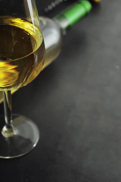 テーブルの上に白い乾燥ワインの透明なボトル 木製の壁の背景に白ワイングラス — ストック写真