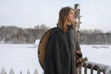 Defender'ı posta zırh genç savaşçı bir kılıç ve balta ile silahlı