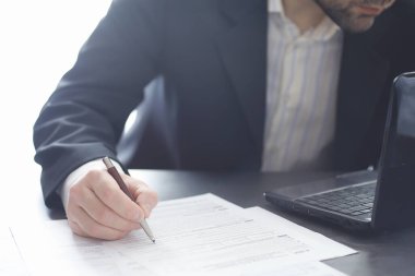 Müdür ofisteki bir dizüstü bilgisayarda çalışıyor. İşadamı çevrimiçi işlem yapıyor. Değiş tokuş internet üzerinden yapılıyor..
