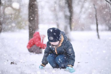 Çocuklar parkta ilk karla yürür.