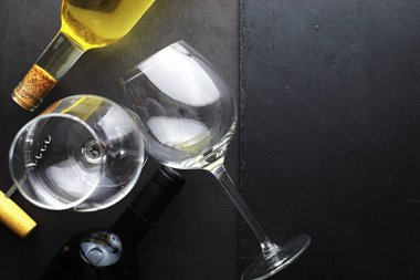 Masada bir bardak kırmızı şarap. Siyah şişe ve bir bardak şarap..