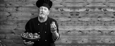 Üniformalı bir ahşap bacground taze sebze ile çiftçi