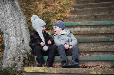 Çocuklar sonbaharda sonbahar parkında yürür