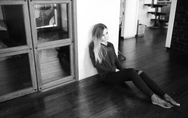 Genç bir kız büyük bir dairede dinleniyor.