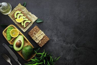 Avokado yemek tarifleri. Tahta kesme tahtasında servis edilen olgun yeşil avokado..