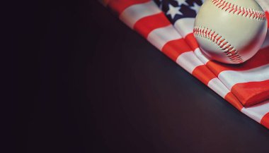 Amerikan geleneksel spor oyunu. Beyzbol mu? Kavram. Amerikan bayrağıyla birlikte beyzbol topu ve sopalar masada..
