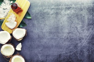 Hindistan cevizi koyu taş bir masada. Hindistan cevizi yağı ve kaşık.