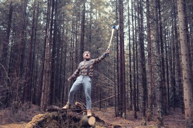 Büyük bir balta ile sakallı bir oduncu ağaç felling önce inceler