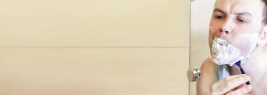 Bir adam sabah işe gitmeden önce banyoda tıraş olur.