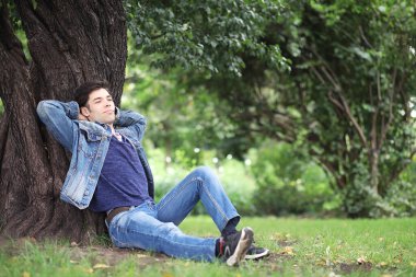 Genç bir adam öğle yemeği zamanında parkta yürür. Bir adam şehirde gezintiye çıktı. Park eden bir öğrenci.