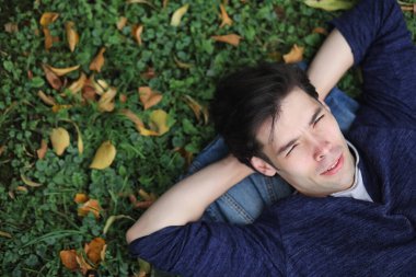 Genç bir adam öğle yemeği zamanında parkta yürür. Bir adam şehirde gezintiye çıktı. Park eden bir öğrenci.