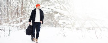 Kışın ormanda bir adam. Sırt çantalı bir turist kışın ormana gider..