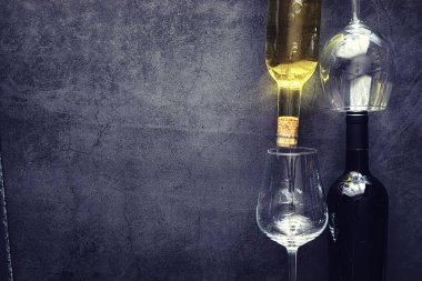 Masada bir bardak kırmızı şarap. Siyah şişe ve bir bardak şarap..