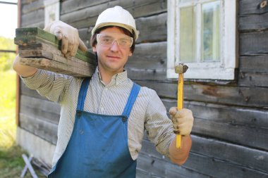 İnşaatçı kılığındaki bir adam bir evi tamir eder.