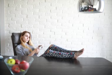 Genç bir kız büyük bir dairede dinleniyor.