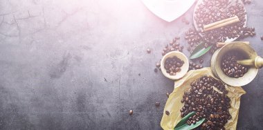 Bir poşet kahve. Kahve çekirdekleri masada kavrulmuş. Pişirmek için yapraklı kahve çekirdekleri.