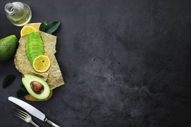 Avokado yemek tarifleri. Tahta kesme tahtasında servis edilen olgun yeşil avokado..