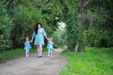 Anne ve iki kız ikizi parkta yürüyüşe çıktılar.