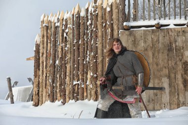 Defender'ı posta zırh genç savaşçı bir kılıç ve balta ile silahlı