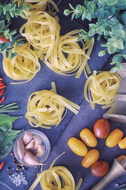 Baharatlı ve sebzeli makarna. Siyah taş üzerinde yemek pişirmek için sebzeli erişte..