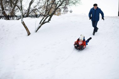 Kışın parktaki çocuklar. Çocuklar parkta karla oynarlar. Kardan adam heykeli yapıp tepelerden aşağı kayıyorlar..