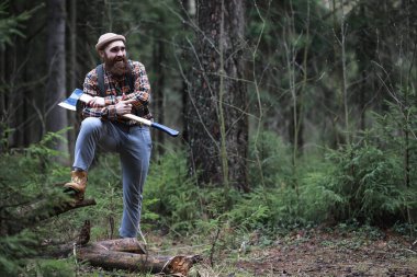 Büyük bir balta ile sakallı bir oduncu ağaç felling önce inceler