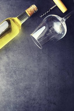 Masada bir bardak kırmızı şarap. Siyah şişe ve bir bardak şarap..