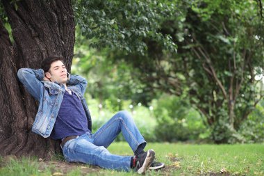 Genç bir adam öğle yemeği zamanında parkta yürür. Bir adam şehirde gezintiye çıktı. Park eden bir öğrenci.