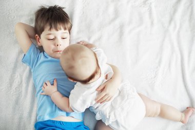 Çocuklar yeni doğan bebeğin yanında yatar, küçük kardeşim. Çocukların duyguları..