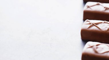 Arkaplanda siyah arka planda çikolatalar. Doldurulmuş çikolata. Atıştırmalık tatlı ve çay.