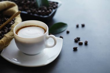 Bir poşet kahve. Kahve çekirdekleri masada kavrulmuş. Pişirmek için yapraklı kahve çekirdekleri.