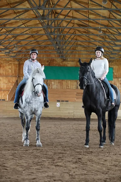 Young people on a horse training in a wooden aren