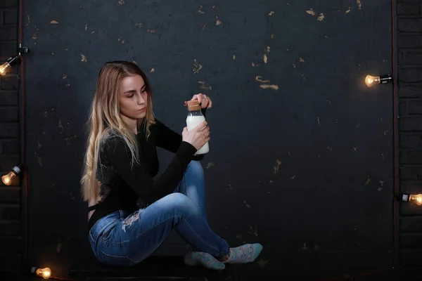 Junges Mädchen Trinkt Milch Aus Einer Flasche Auf Schwarzem Wandhintergrund — Stockfoto