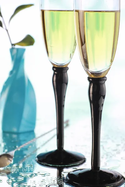Background with tall glasses for sparkling wines. Champagne spray in glass glasses. Celebratory drink with reflection.