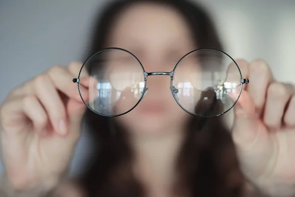 视力差的概念 手拿着隐形眼镜和眼镜 玻璃杯和镜片广告海报 — 图库照片