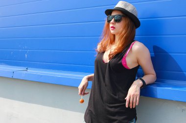 Hafif şapkalı ve güneş gözlüklü bir kız.