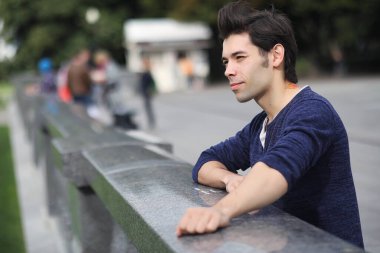 Genç bir adam öğle yemeği zamanında parkta yürür. Bir adam şehirde gezintiye çıktı. Park eden bir öğrenci.