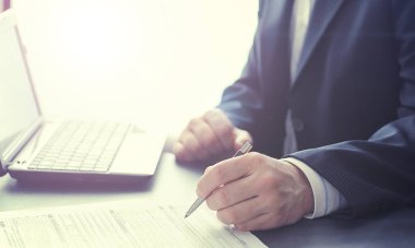 Müdür ofisteki bir dizüstü bilgisayarda çalışıyor. İşadamı çevrimiçi işlem yapıyor. Değiş tokuş internet üzerinden yapılıyor..