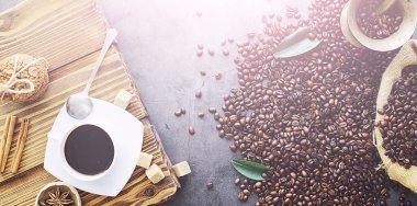 Bir poşet kahve. Kahve çekirdekleri masada kavrulmuş. Pişirmek için yapraklı kahve çekirdekleri.