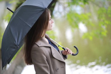 Rai 'deki bir bahar parkında ceketli genç bir kız.