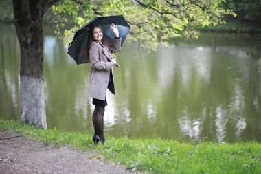 Rai 'deki bir bahar parkında ceketli genç bir kız.