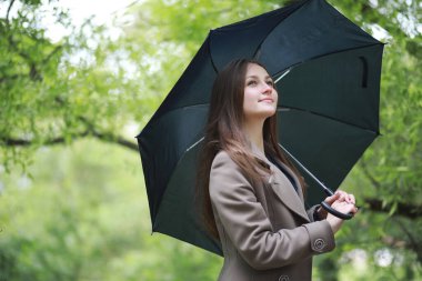 Rai 'deki bir bahar parkında ceketli genç bir kız.