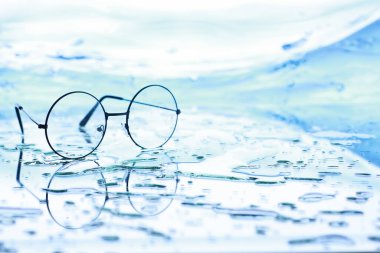 Görme düzeltmesi için araçlar. Sıçrama ve bulanıklığın arka planında diopterleri olan gözlük ve lensler.