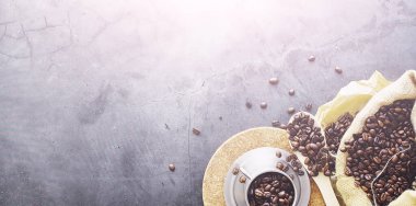 Bir poşet kahve. Kahve çekirdekleri masada kavrulmuş. Pişirmek için yapraklı kahve çekirdekleri.