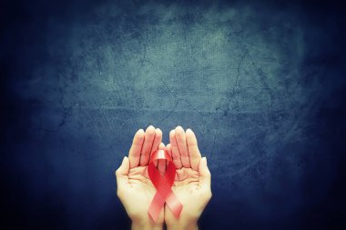 İnsan bağışıklık yetmezliği virüsü hastalığının sembolü. Kırmızı kurdele. Yardım eli ve destek. Arkaplan.