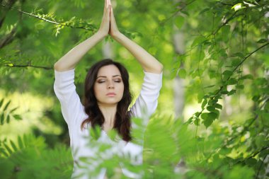 Hamile kadın bir yaz doğada Yoga egzersiz yaparak