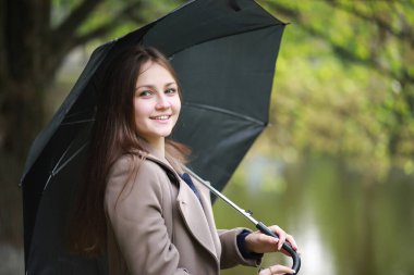 Rai 'deki bir bahar parkında ceketli genç bir kız.